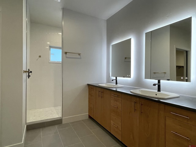 bathroom with double vanity, a walk in shower, a sink, and tile patterned floors
