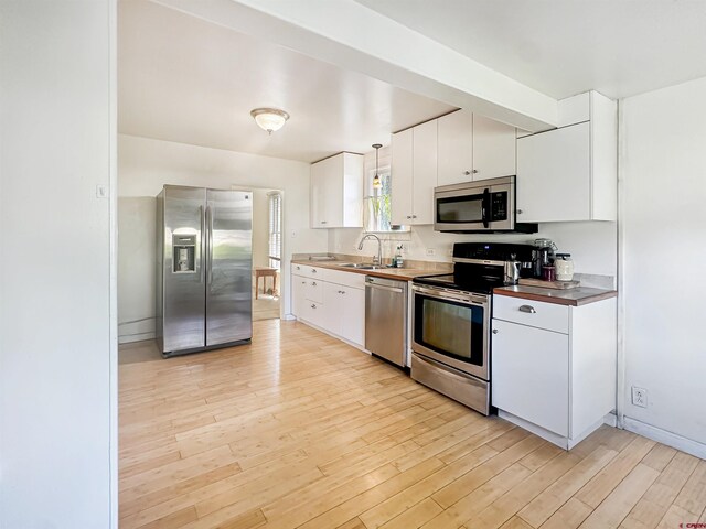 bedroom featuring light hardwood / wood-style floors, sink, and stainless steel fridge