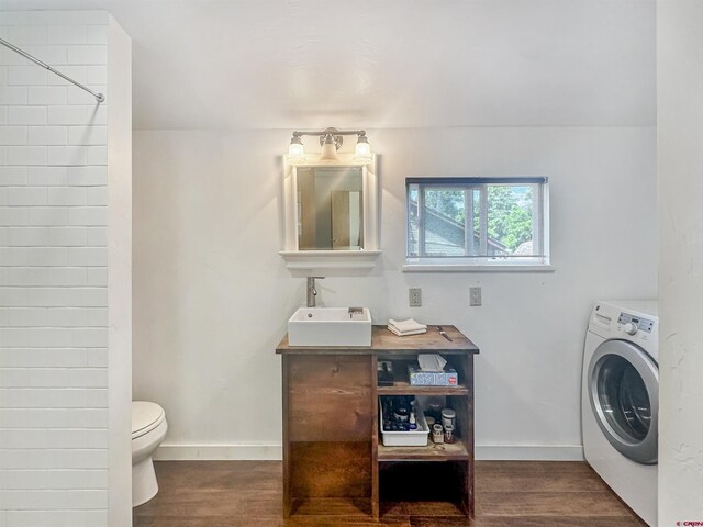 laundry room featuring sink, washer / dryer, and dark wood-type flooring