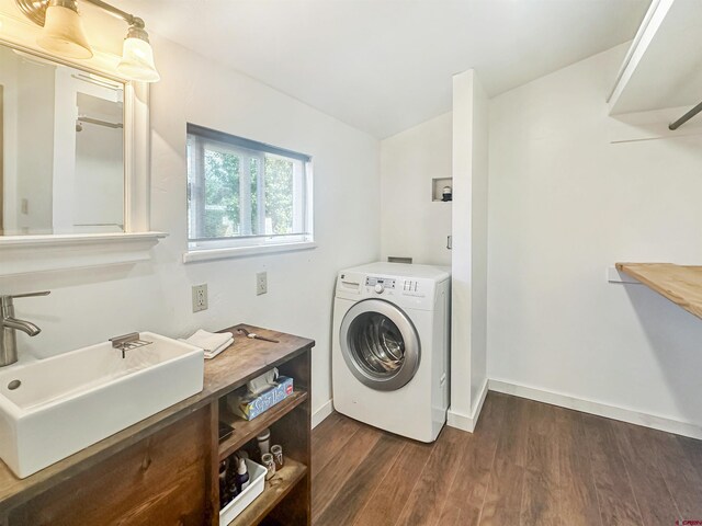 washroom with washer / dryer, sink, and dark wood-type flooring