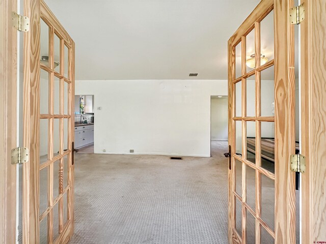 unfurnished room featuring carpet flooring, french doors, and plenty of natural light