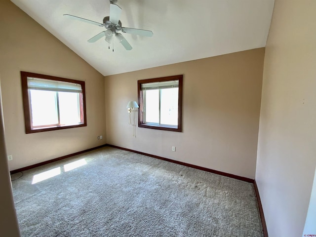 carpeted spare room with ceiling fan and vaulted ceiling