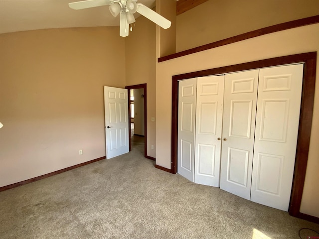 unfurnished bedroom with ceiling fan, a closet, a towering ceiling, and light carpet