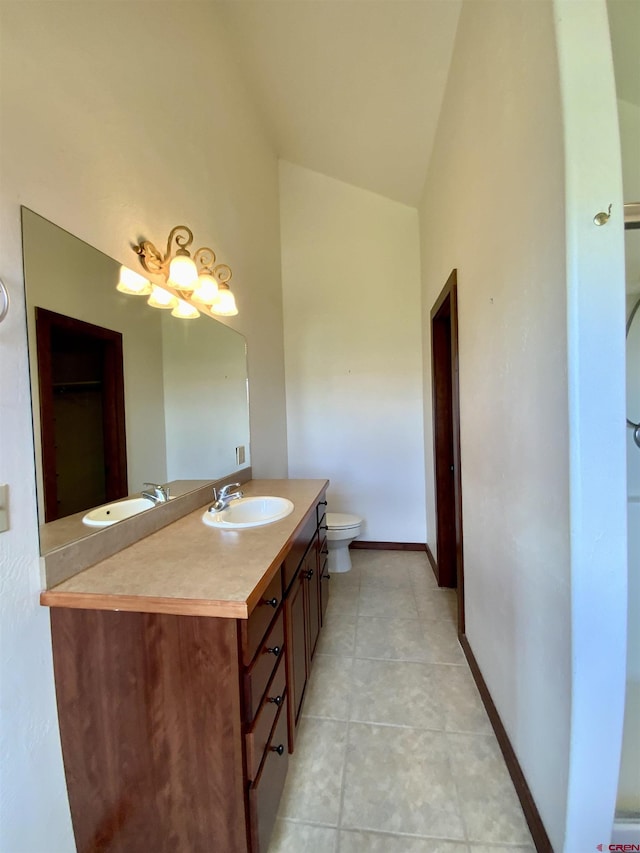 bathroom featuring tile patterned floors, vanity, vaulted ceiling, and toilet