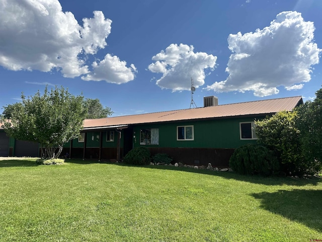 rear view of property with a yard and central air condition unit