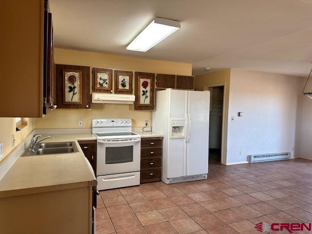 kitchen with white appliances, sink, light tile patterned floors, and a baseboard heating unit