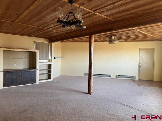 unfurnished living room with carpet flooring and wooden ceiling