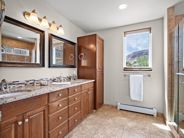 bathroom featuring a shower with door, vanity, a baseboard heating unit, and tile patterned flooring