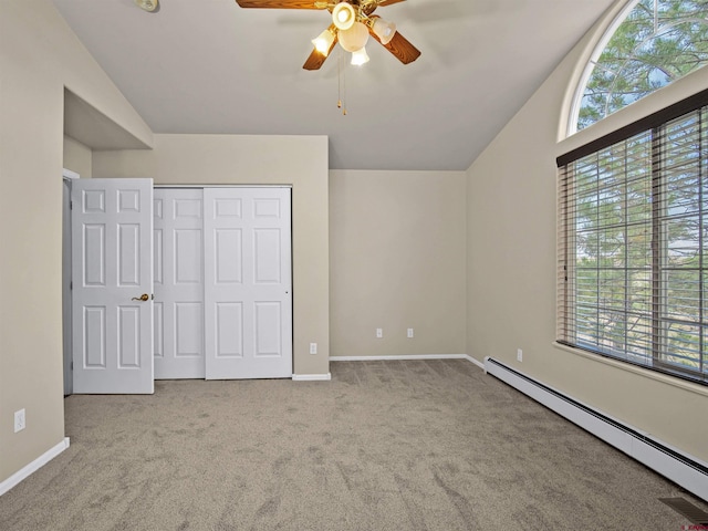 unfurnished bedroom with multiple windows, a baseboard radiator, lofted ceiling, and light carpet