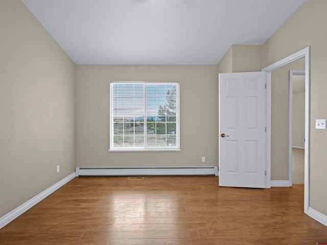 unfurnished room with hardwood / wood-style floors and a baseboard radiator