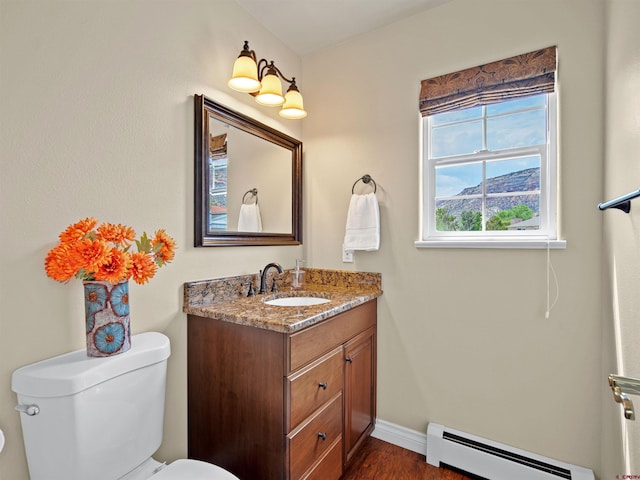 bathroom with hardwood / wood-style flooring, vanity, baseboard heating, and toilet