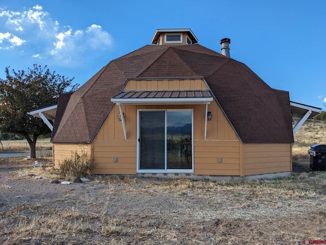rear view of house featuring metal roof
