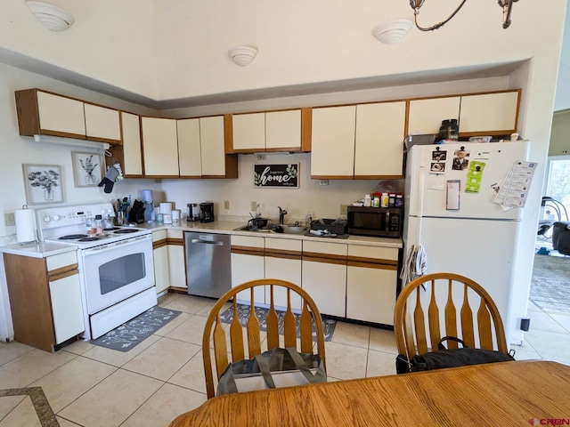 kitchen with cream cabinets, sink, appliances with stainless steel finishes, and light tile patterned flooring