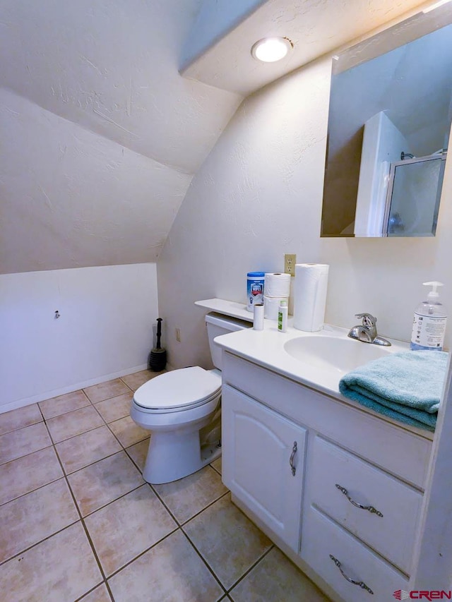 bathroom with vanity, tile patterned flooring, toilet, and vaulted ceiling