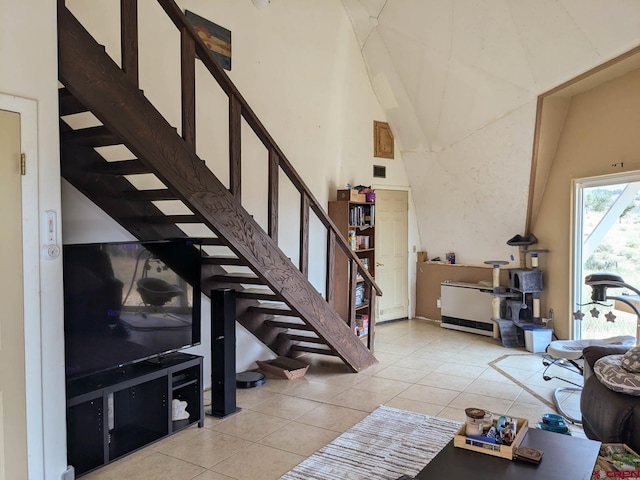 living room with light tile patterned floors and a high ceiling