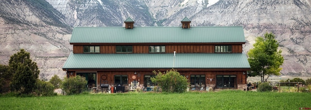 rear view of house featuring a lawn and a mountain view