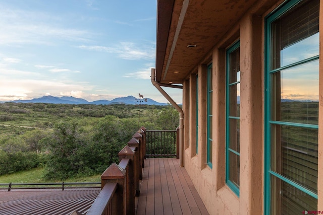 balcony at dusk featuring a mountain view