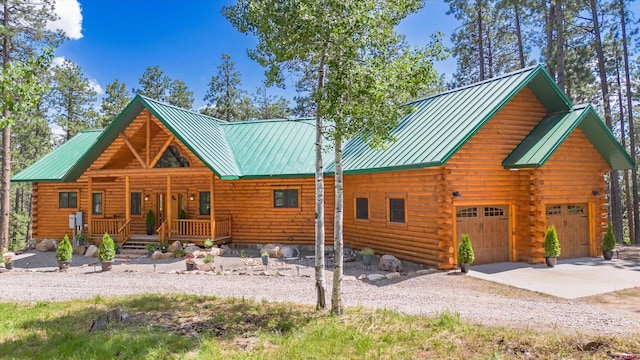 log-style house featuring log siding, a porch, metal roof, and a standing seam roof