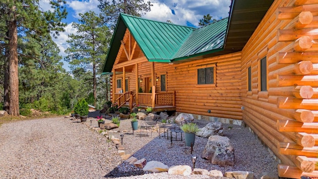 view of side of property with log siding, metal roof, and a standing seam roof