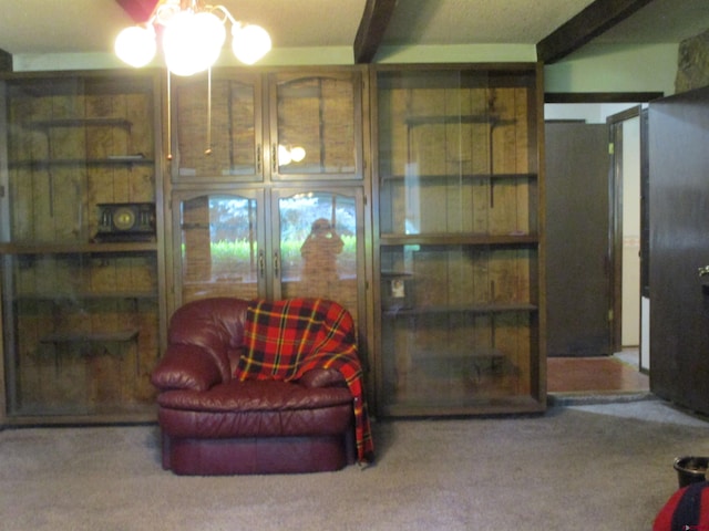 living area with carpet flooring and beam ceiling