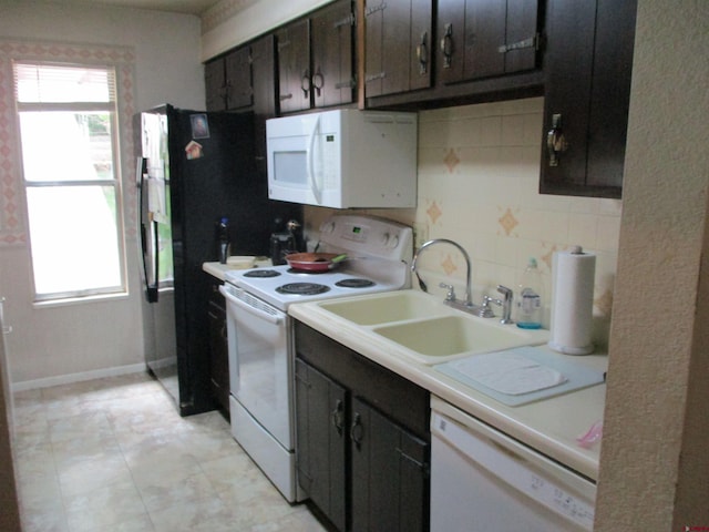 kitchen featuring backsplash, sink, dark brown cabinetry, and white appliances