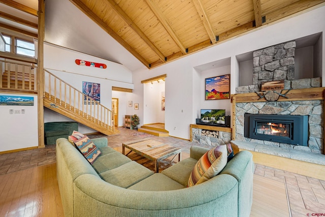 living room with wood ceiling, a stone fireplace, beamed ceiling, and high vaulted ceiling