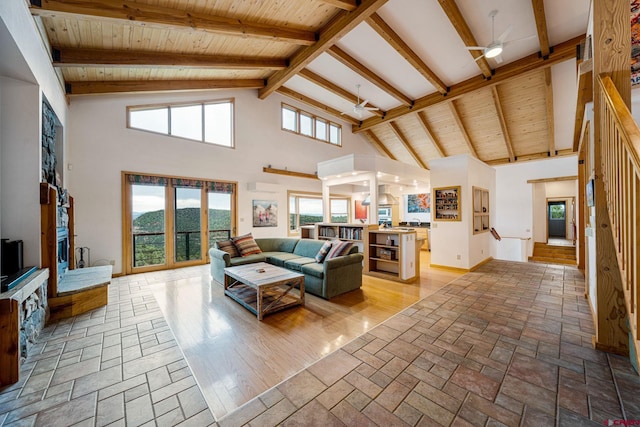 living room featuring high vaulted ceiling, beamed ceiling, and light wood-type flooring