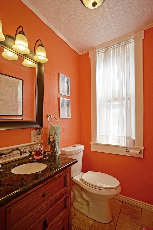 bathroom with a wealth of natural light, toilet, vanity, and crown molding