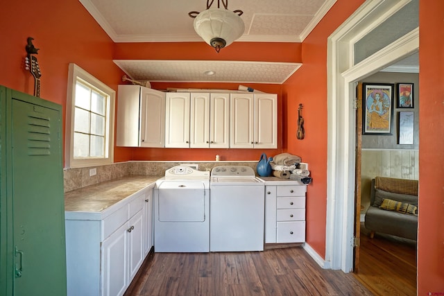 laundry room with washing machine and dryer, cabinets, dark hardwood / wood-style flooring, and ornamental molding