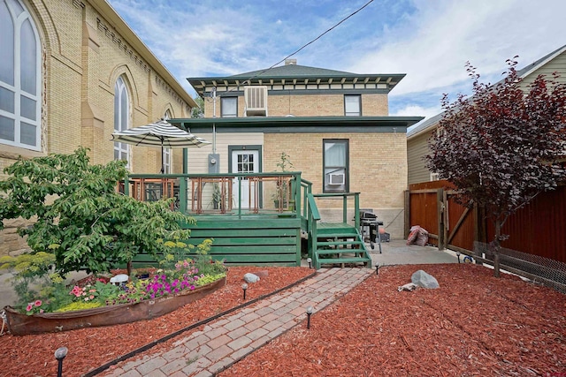 rear view of property featuring a wooden deck and a patio