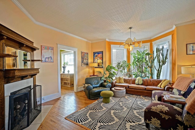 living room featuring a textured ceiling, an inviting chandelier, ornamental molding, and light hardwood / wood-style flooring