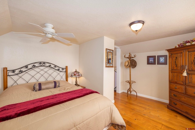 bedroom featuring light hardwood / wood-style flooring, a textured ceiling, and ceiling fan