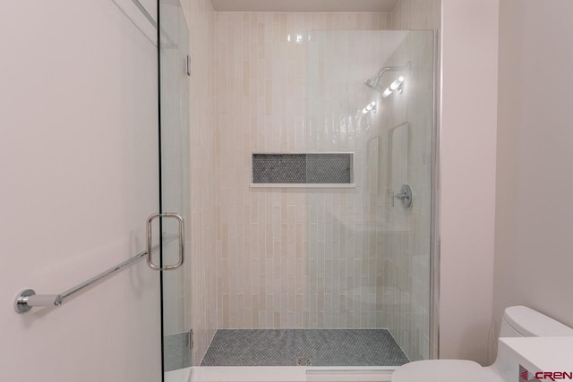 bathroom featuring vanity, toilet, and a shower with door