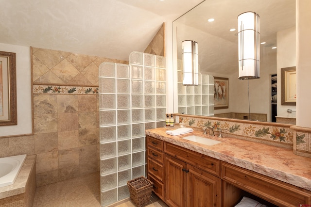 bathroom featuring vanity, tile walls, and tiled bath