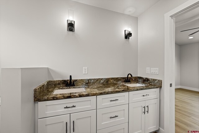 bathroom with double vanity and hardwood / wood-style flooring