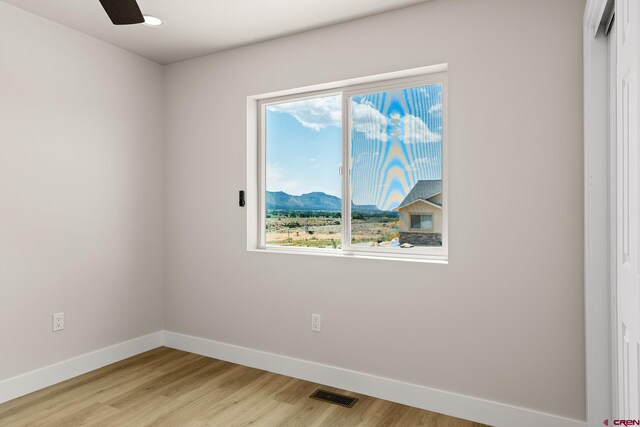 unfurnished room with a healthy amount of sunlight, ceiling fan, and light wood-type flooring