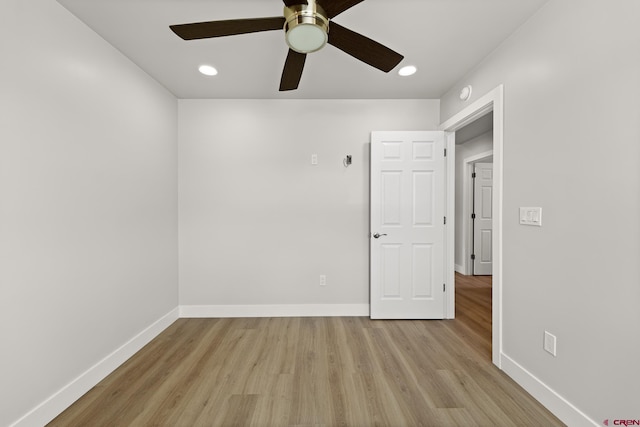 spare room with ceiling fan and light wood-type flooring