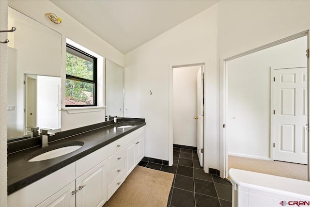 bathroom with tile patterned floors, vaulted ceiling, and vanity