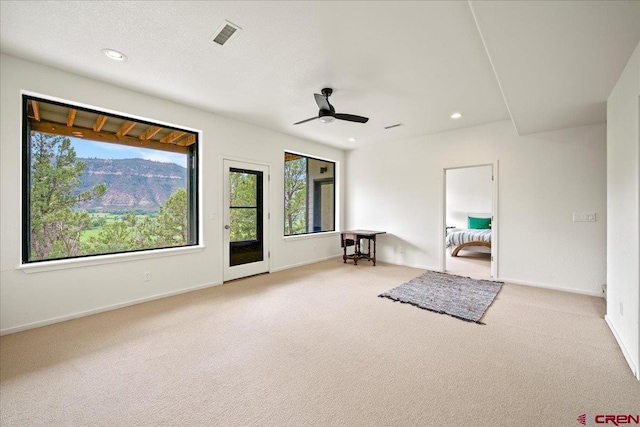 interior space with ceiling fan and light carpet