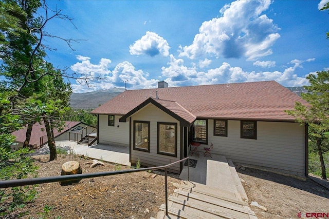 view of front facade featuring a mountain view and a patio area