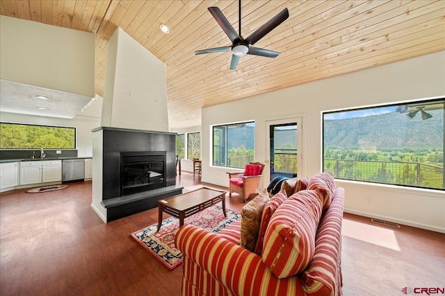 living room featuring sink, plenty of natural light, wooden ceiling, and a multi sided fireplace