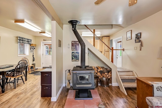 living room with a wood stove and wood-type flooring