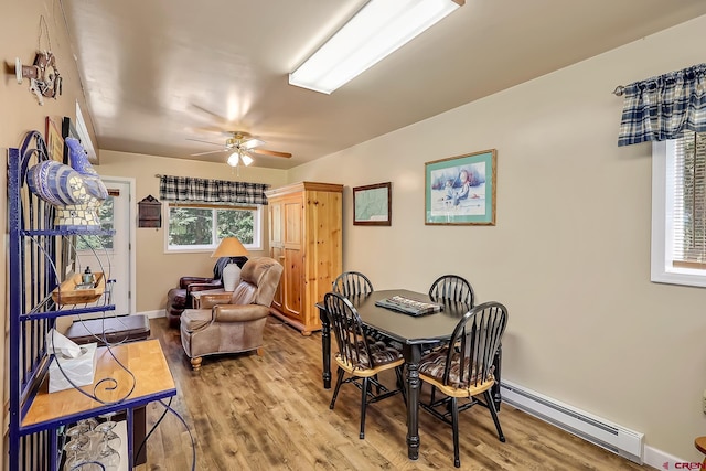 dining room featuring baseboard heating, light hardwood / wood-style flooring, and ceiling fan