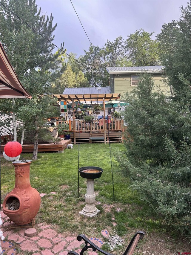 view of yard with a wooden deck and an outdoor fire pit