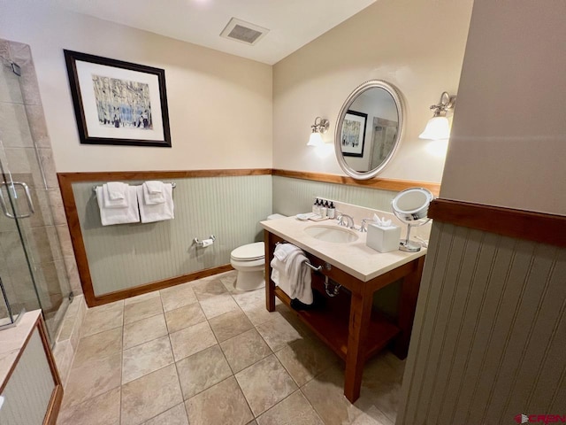 bathroom featuring vaulted ceiling, tile patterned floors, a shower with shower door, vanity, and toilet