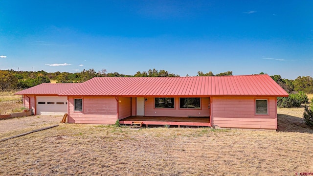 ranch-style house featuring a garage, metal roof, and driveway