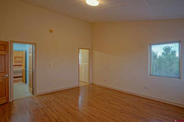 tiled spare room with high vaulted ceiling