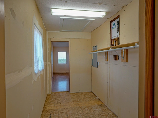 hallway featuring electric panel and light hardwood / wood-style flooring