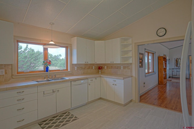 kitchen with white cabinetry, sink, white dishwasher, light tile patterned floors, and backsplash