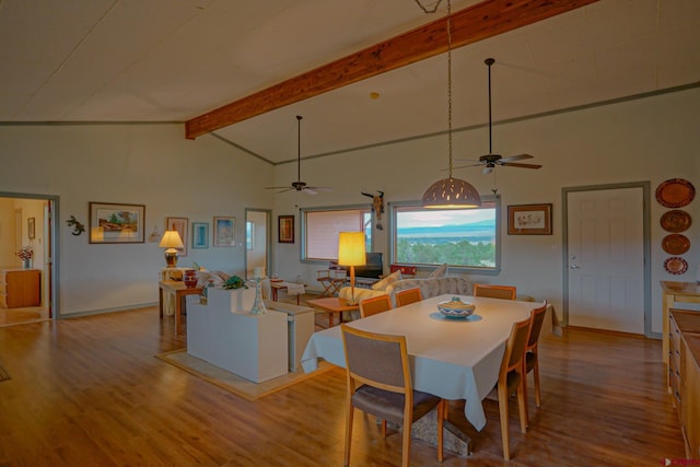 dining space with beam ceiling, hardwood / wood-style flooring, high vaulted ceiling, and ceiling fan